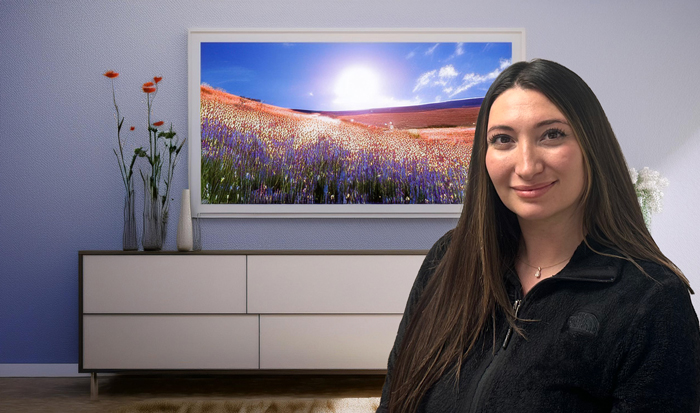 Caroline Peterson new patient coordinator with colorful meadow flower picture behind her